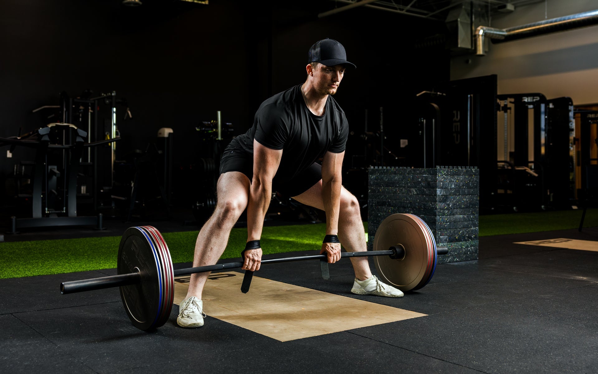 An athlete deadlifting with Rep Fitness Calibrated Steel Plates (KG) loaded on the barbell, highlighting how thin the plates are