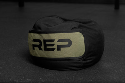 Black and green stone sandbag with 'REP' branding on a dark surface